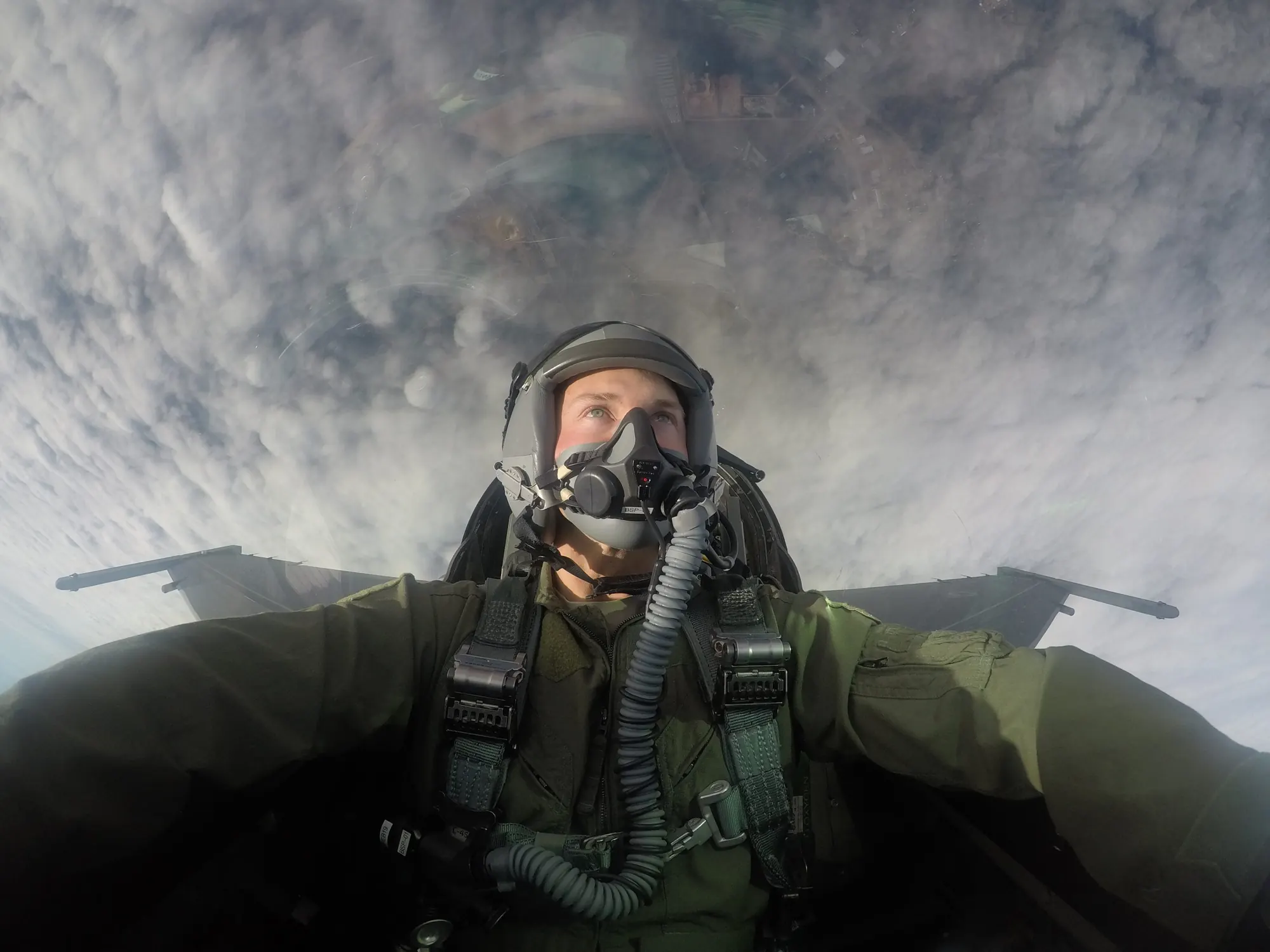 Cabana Breeze owner Dillon Johnson in a flight helmet and oxygen mask in a jet cockpit during his military service
