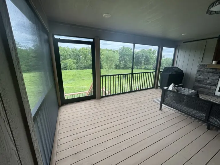 After: the covered porch enclosed with dark screens, a screen door and integrated aluminum railing
